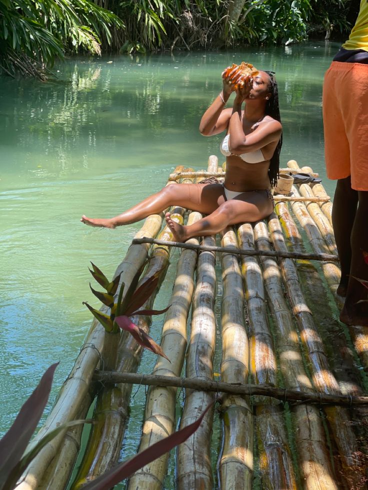 a woman sitting on top of a bamboo raft