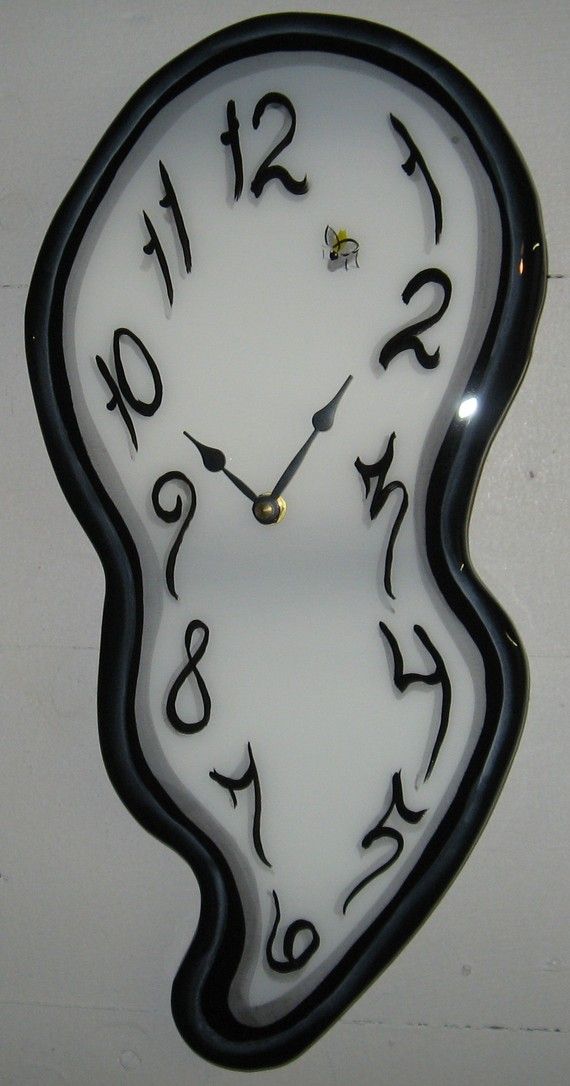 a white clock with black numbers on it's face is hanging from the wall