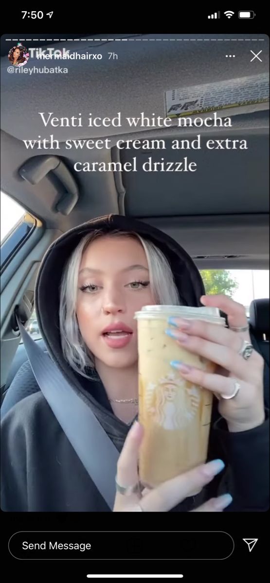 a woman holding a drink in her car