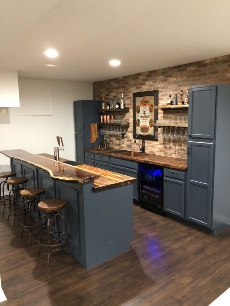 a kitchen with an island and bar stools next to the counter top that is built into the wall