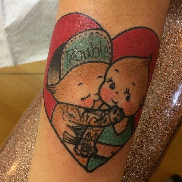 a couple hugging each other in a heart shaped tattoo