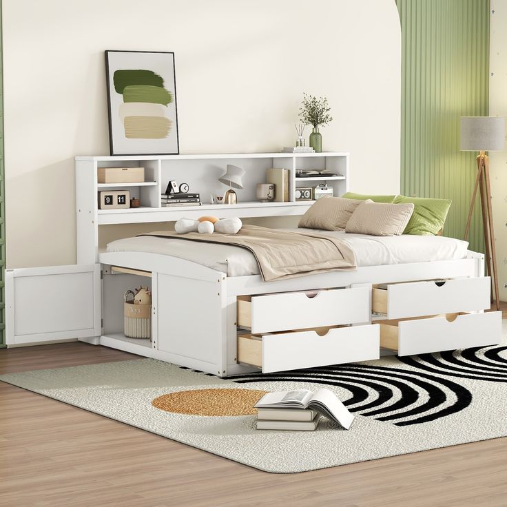 a white bed with drawers underneath it in a room