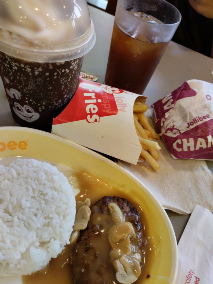 a plate topped with rice and meat covered in gravy