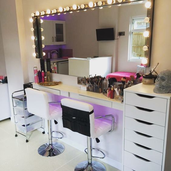 a mirror sitting on top of a counter next to two stools in front of it