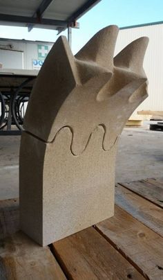 a large stone sculpture sitting on top of a wooden table next to a bike rack