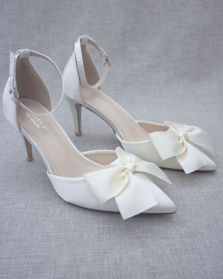 An all-time classic and elegant style with simplicity of satin pointy toe heels and added front satin bow with removable ankle strap. DETAILS: HEELS: 3 inches COLORS AVAILABLE: Black, Burgundy, Champagne, Dusty Pink, Light Blue, Ivory, and White UPPER: Synthetic upper and lining MATERIALS: Mandmade outsole ORIGIN: Imported STYLE NAME: BELL Bow Detail Heels For Prom, Fitted Bow Heels For Prom, Prom Heels With Bow, Pointed Toe Kitten Heels With Bow For Party, Formal Wedding Shoes With Ankle Strap And Bow, Chic Wedding Shoes With Satin Bow For Party, Elegant Wedding Shoes With Satin Bow For Prom, Elegant Formal Wedding Shoes With Satin Bow, Formal Wedding Shoes With Bow