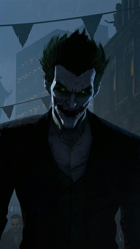 the joker is standing in front of an evil looking man with green eyes and dark hair