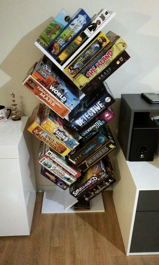 a stack of magazines sitting on top of a wooden floor next to a white cabinet