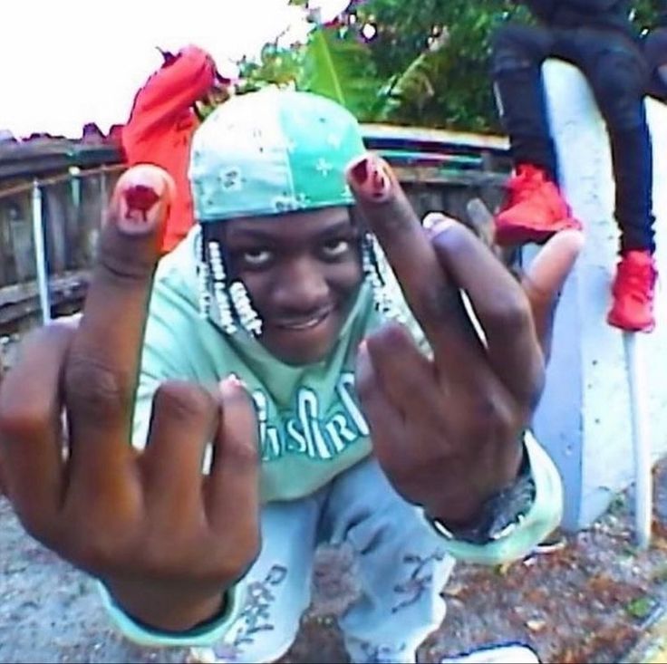 a young man is posing for a selfie with his hands in front of him