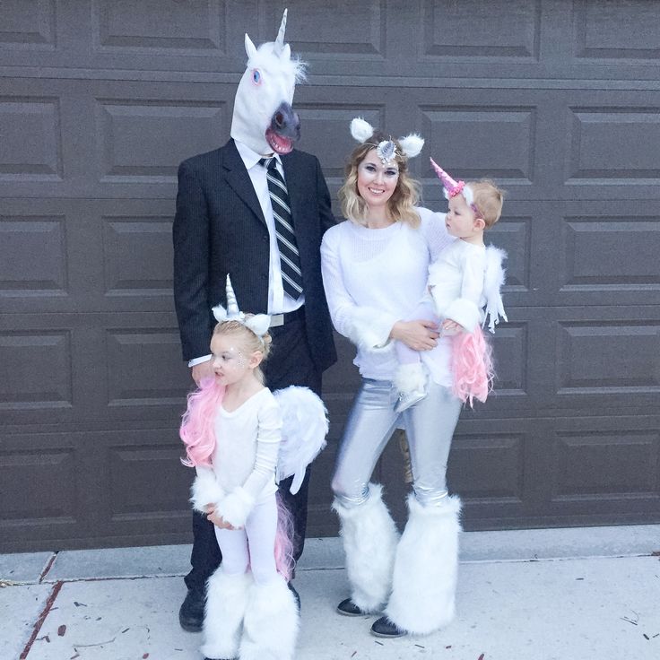 a family dressed up as unicorns and horses posing for a photo in front of a garage door