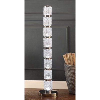 a tall glass lamp on top of a wooden table