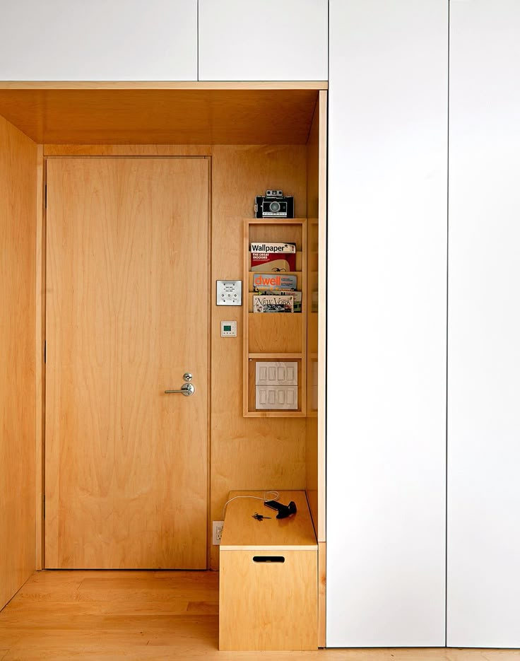 an open wooden door in a white room