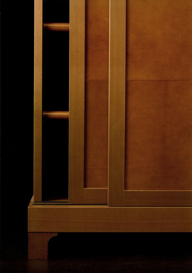 a wooden cabinet with glass doors on the top and bottom, against a black background