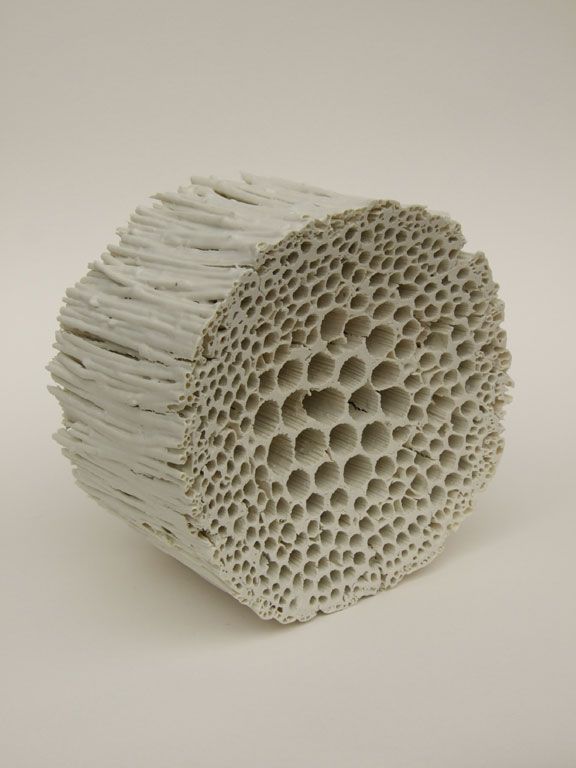 a white sculpture with holes in the middle