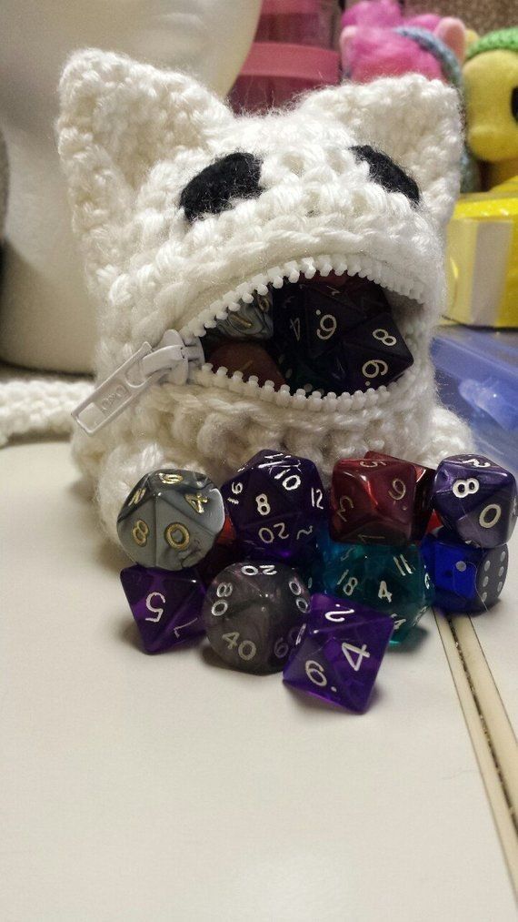 a stuffed animal with some dice in it's mouth and other toys on the table