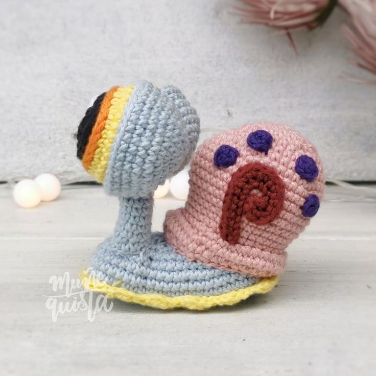 a crocheted toy snail with its mouth open