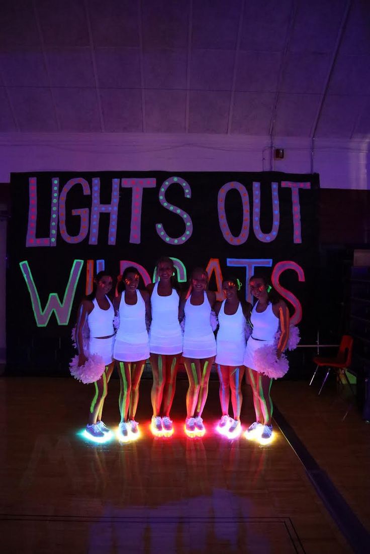 a group of young women standing on top of a basketball court in front of a sign