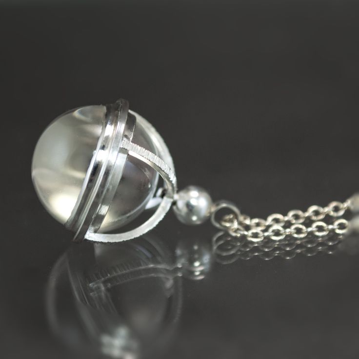 Specifications: Metal: Sterling Silver Stone: Natural Rock Crystal Quartz Sphere, 18mm Size: 1 5/16in length x 7/8in width Inspired by the Pools of Light jewelry motif of the Victorian era and fabricated in the fashion of an antique watch fob of the same time period, this hand-fabricated sterling silver necklace features an 18mm natural rock crystal sphere. A precisely calibrated spectacle setting suspends the flawless quartz orb within an arched framework, the armature of which has been given a Antique Metal Jewelry As Gift, Antique Metal Jewelry For Gifts, Antique Metal Jewelry Gift, Antique Metal Jewelry For Gift, Timeless Nickel-free Sterling Silver Jewelry, Timeless Sterling Silver Nickel-free Jewelry, Elegant Stainless Steel Medallion Necklace, Elegant Stainless Steel Jewelry With Polished Finish, Luxury Formal Pendant Jewelry