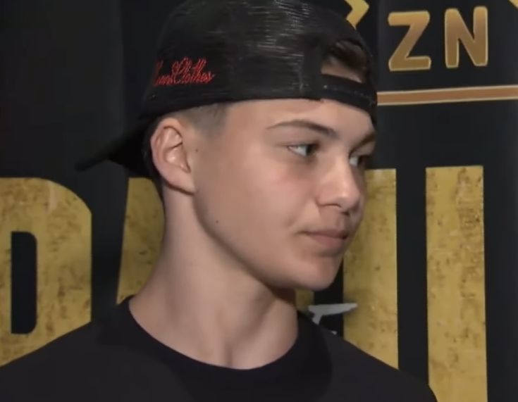 a young man wearing a black baseball cap