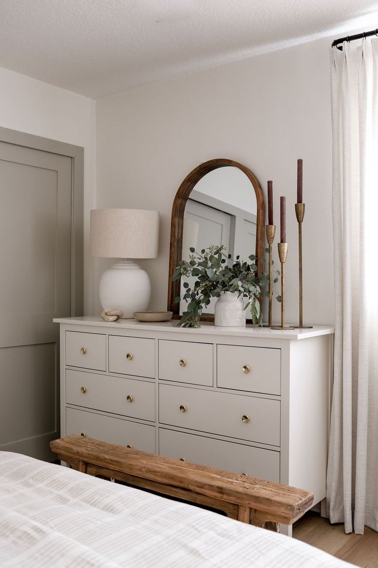 a white dresser with a mirror and plants on top