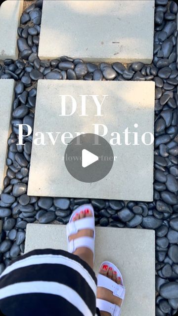 a woman standing on top of a stone walkway next to rocks and pebbles with the words diy paver patio