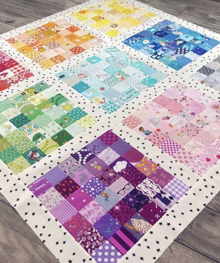 a multicolored patchwork quilt on a wooden floor