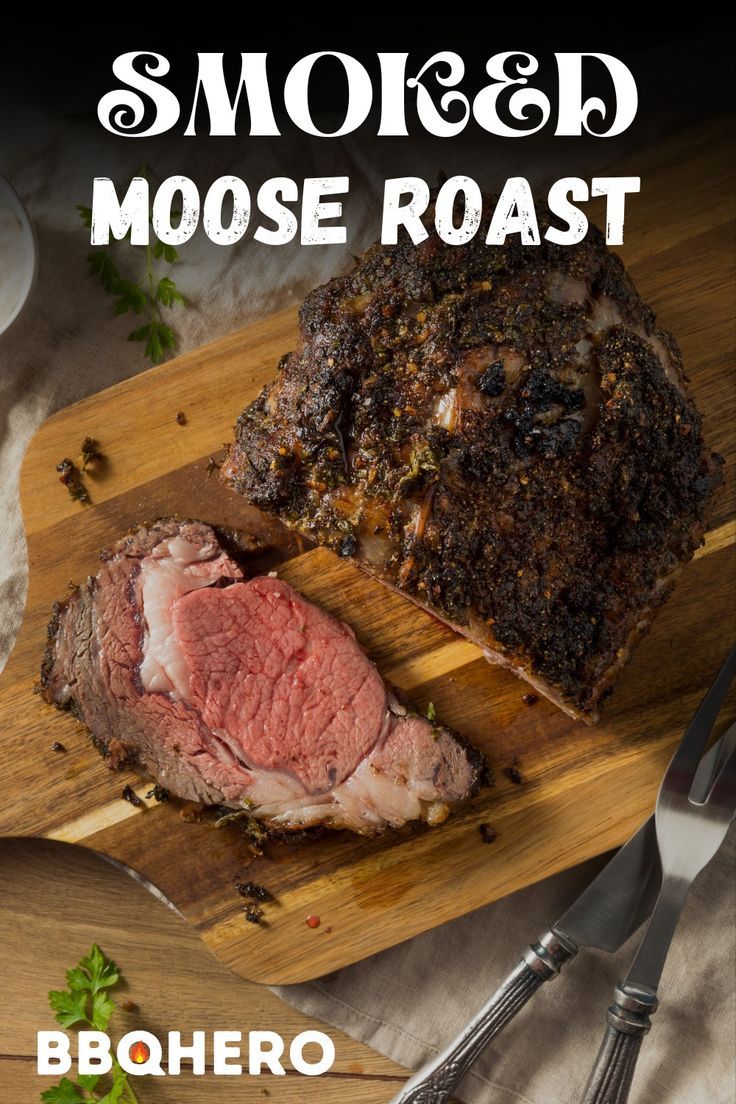 a piece of meat sitting on top of a cutting board next to a knife and fork