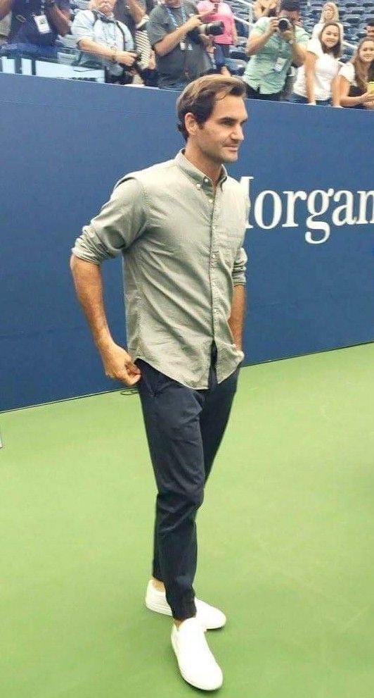 a man standing on top of a tennis court holding a racquet in his hand