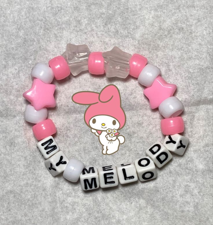 a pink and white bracelet that says my melody