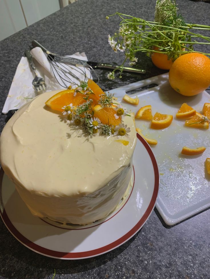 there is a cake with oranges on the table