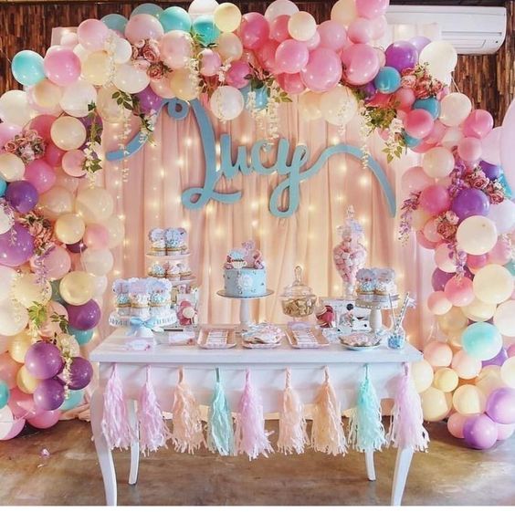 a table topped with lots of balloons and cake