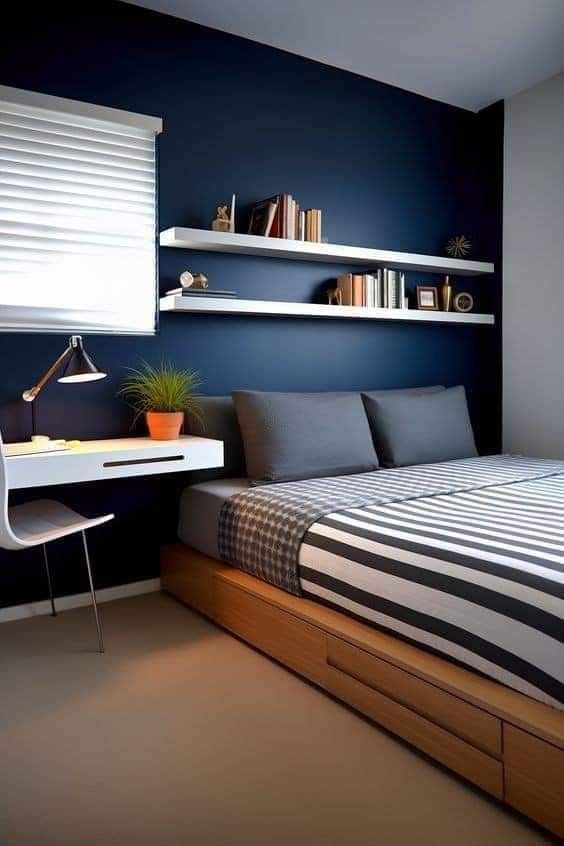 a bedroom with a bed, desk and bookshelf on the wall above it