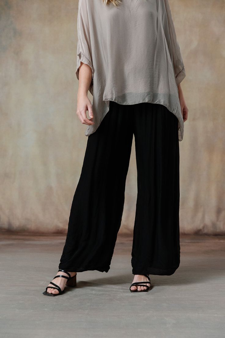 You'll swoon over our Madelyn Pants, where luxurious Italian silk meets impeccable design. These pants feature a comfortable waistband and a flattering wide-leg cut, offering a perfect blend of elegance and ease. Available in stunning colorways that seamlessly coordinate with our effortless tops and cozy knitwear, the Madelyn Pants make full-body dressing an art form. Part of our mix-and-match Italian Silk assortment. Classic fit. One size fits most. Full-length wide-leg pant, foldable jersey wa Viscose Wide-leg Pants With Elastic Waistband, Loosely Fitted Viscose Wide Leg Pants, Chic Wide-leg Viscose Pants, Chic Full Length Wide Leg Viscose Pants, Chic Full-length Wide Leg Viscose Pants, Chic Full Length Viscose Wide Leg Pants, Elegant Ankle-length Viscose Wide Leg Pants, Solid Wide-leg Viscose Pants, Solid Viscose Wide-leg Pants