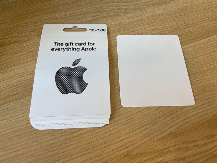 an apple gift card is sitting on a wooden table next to it's packaging