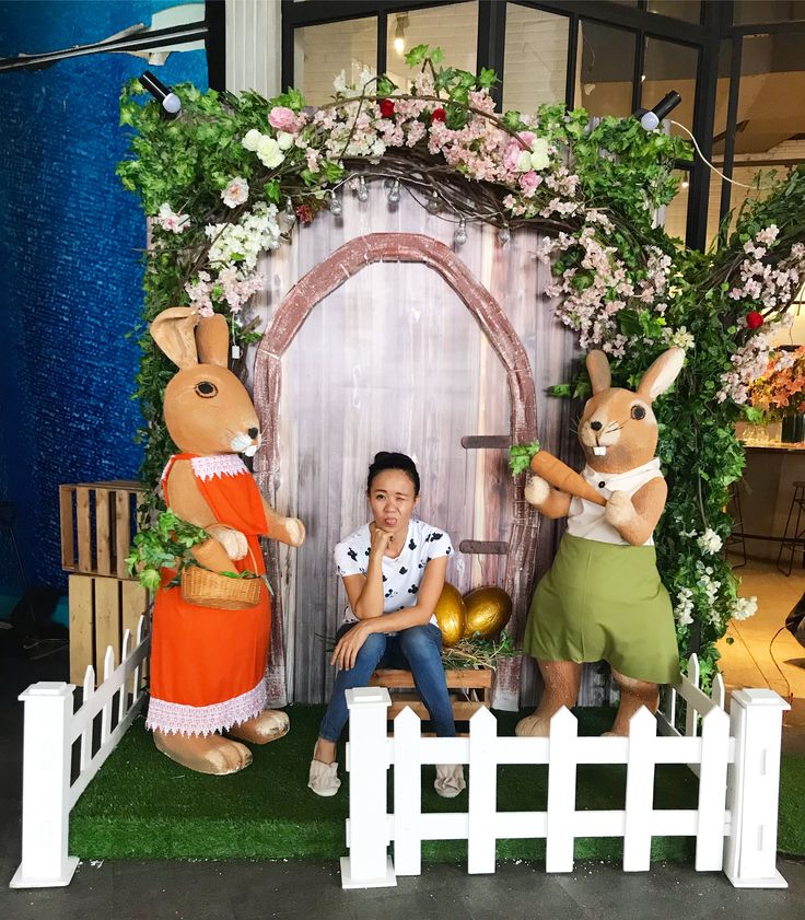 a woman sitting in front of a fake door with two rabbits on top of it