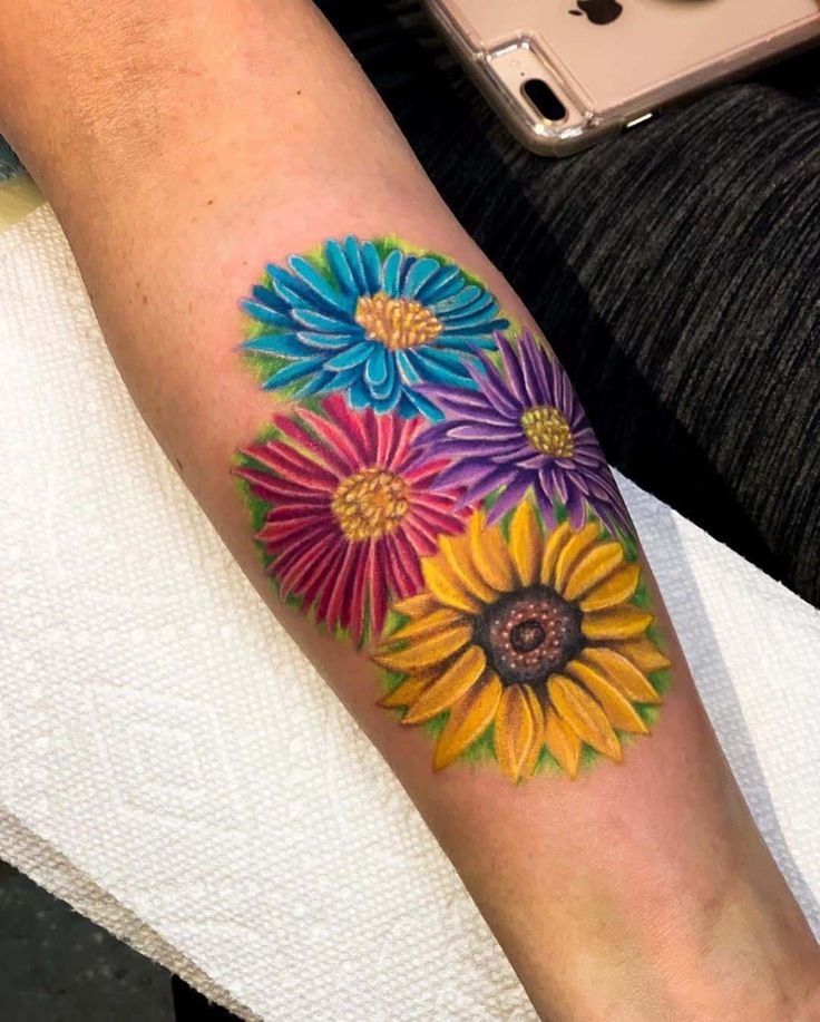 a woman's arm with colorful flowers on it