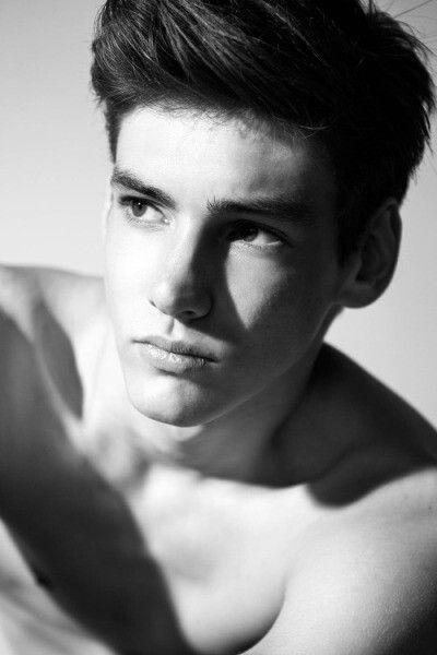 a shirtless young man is posing for a black and white photo with his hand in the air