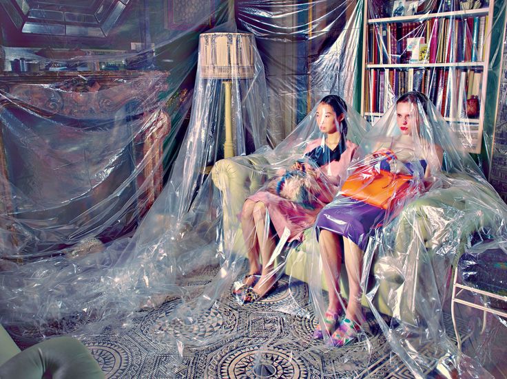 two women sitting on chairs covered in plastic