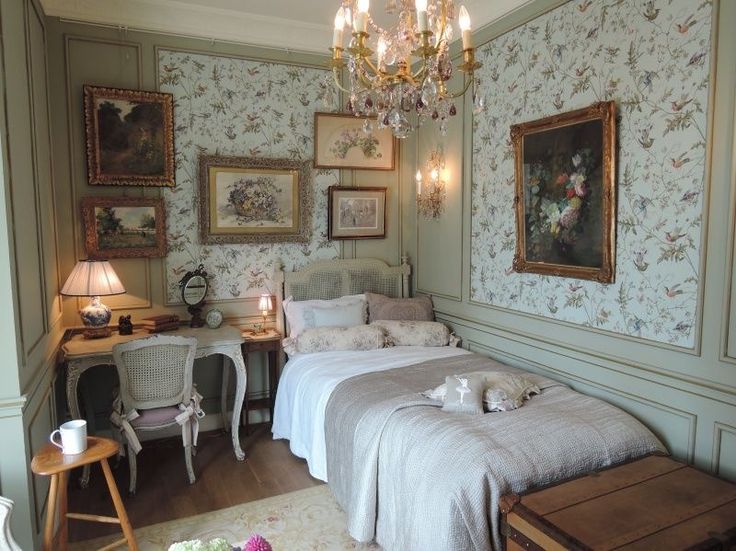 a bedroom with floral wallpaper and chandelier