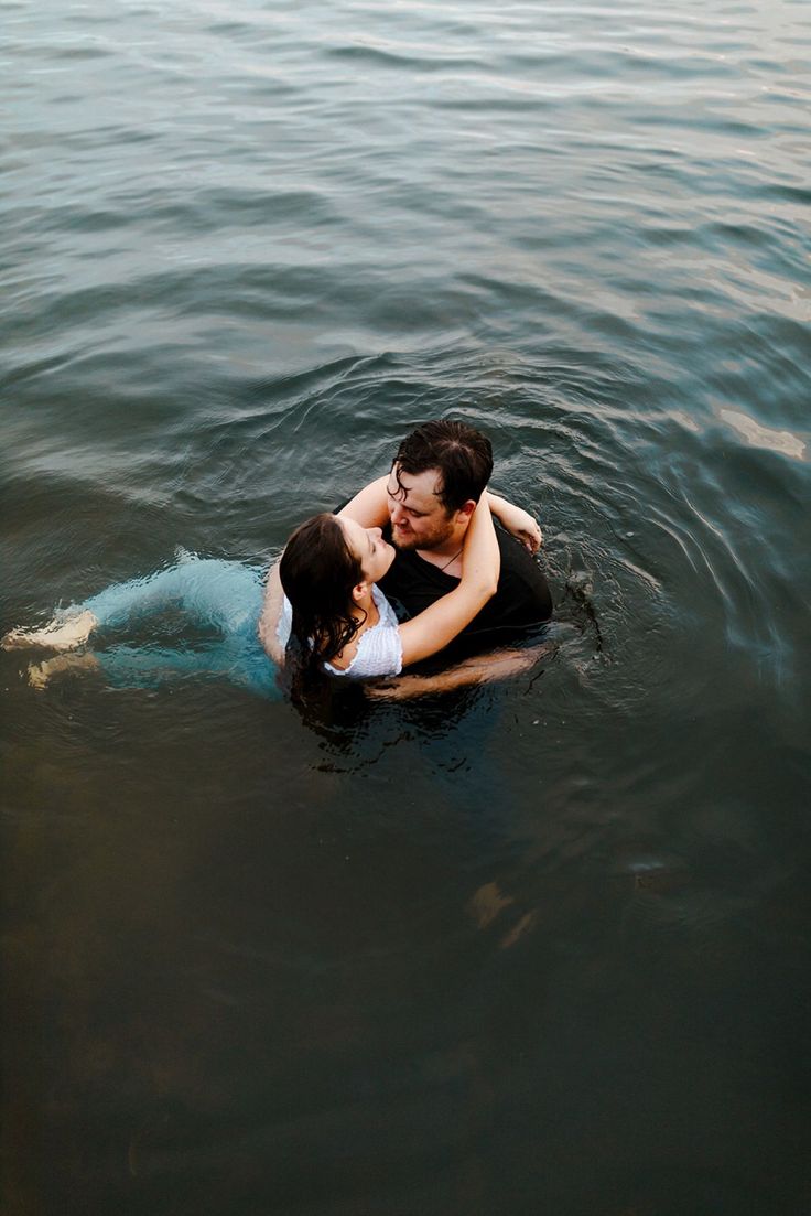 a man and woman are kissing in the water