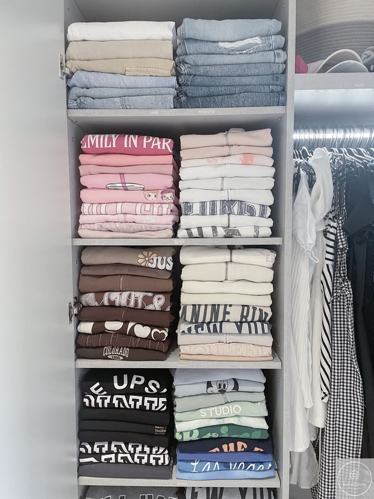 an organized closet with folded clothes and t - shirts