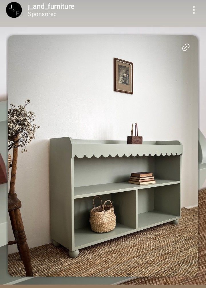 a room with a book shelf, basket and vase on the floor next to it