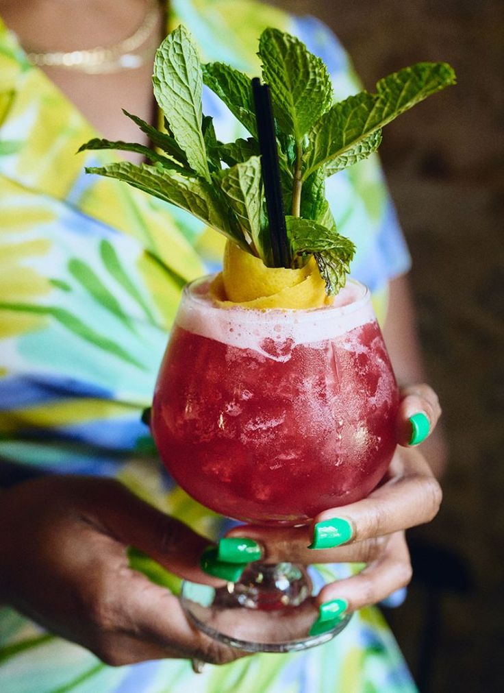 a woman holding a drink in her hand