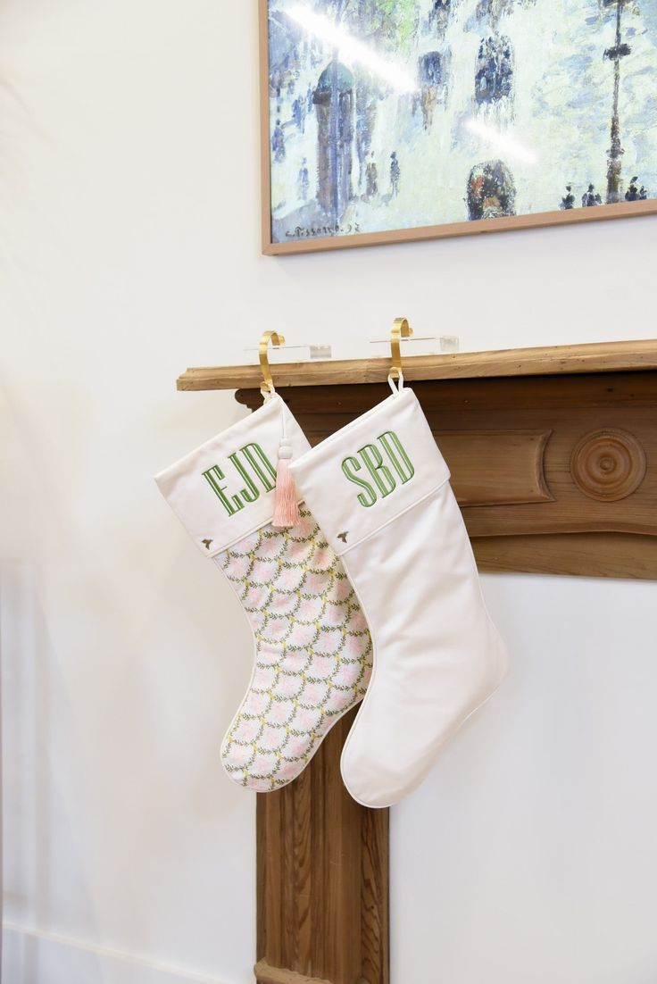 two christmas stockings hanging from a mantel