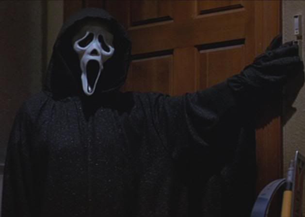 a person wearing a ghost mask and holding a cell phone in front of a door