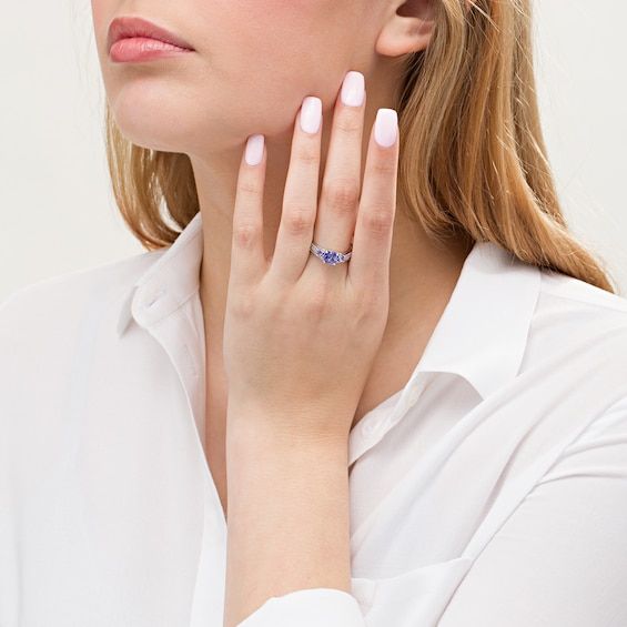 The perfect mix of classic and modern, this gemstone and diamond bridal set is the unique look she's been searching for. Created in 14K white gold, the three-stone engagement ring showcases a trio of cushion-cut violet-blue tanzanites - the largest the 6.0mm center stone. Diamonds adorn the shank for a sparkling style. On your wedding day, complete her ensemble with the contoured diamond-lined band. Radiant with 1/4 ct. t.w. of diamonds and a brilliant buffed luster, this bridal set shines with Elegant Tanzanite Birthstone Ring With Prong Setting, Elegant Asscher Cut Birthstone Ring With Prong Setting, Elegant Tanzanite Diamond Ring For Wedding, Elegant Tanzanite Birthstone Ring For Promise, Elegant Tanzanite Diamond Cut Ring, Elegant Baguette Cut Diamond Birthstone Ring, Elegant Diamond White Sapphire Ring, Elegant Tanzanite Diamond Wedding Ring, Formal Cubic Zirconia Birthstone Ring