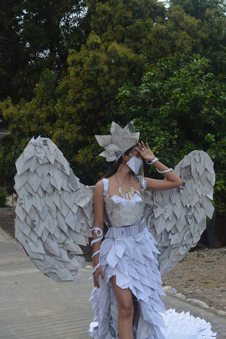 a woman is dressed up like an angel with wings on her head and dress made out of paper