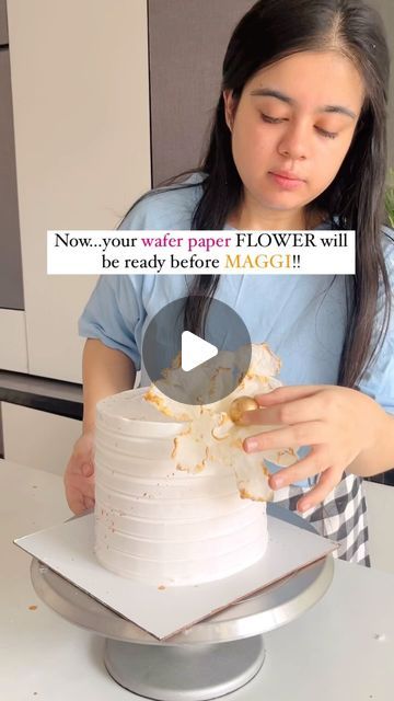 a woman is decorating a cake with white frosting