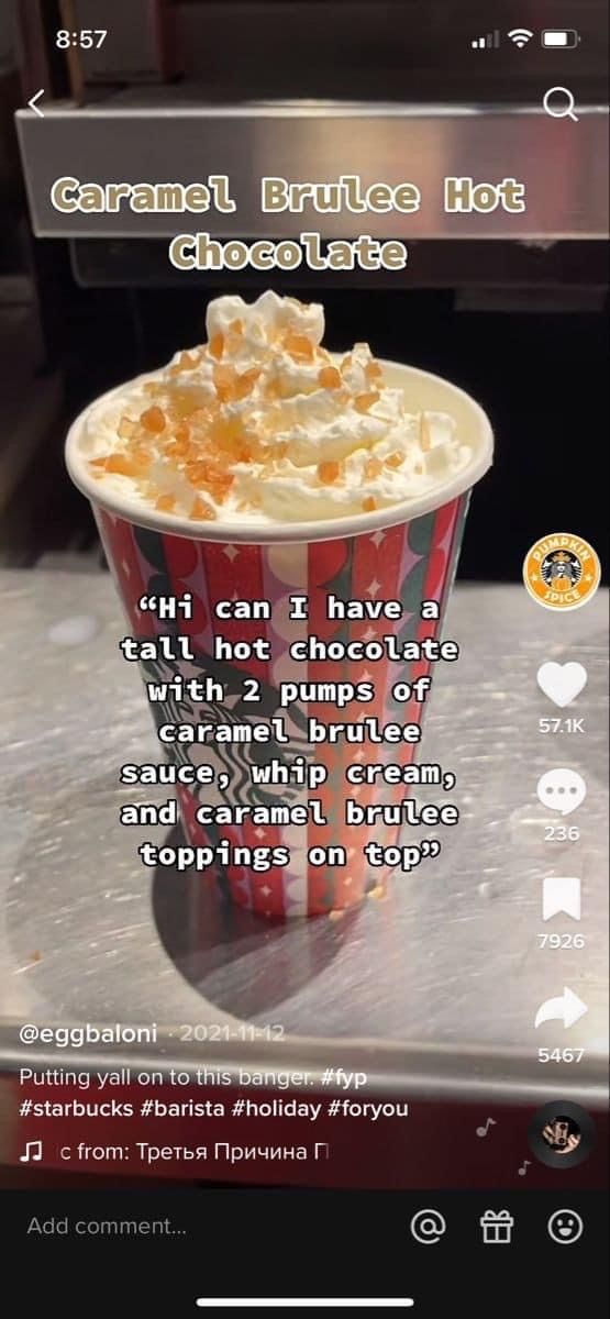 a cup filled with whipped cream sitting on top of a counter next to a menu