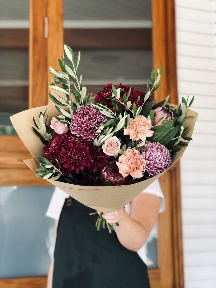 a woman holding a bouquet of flowers in her hands